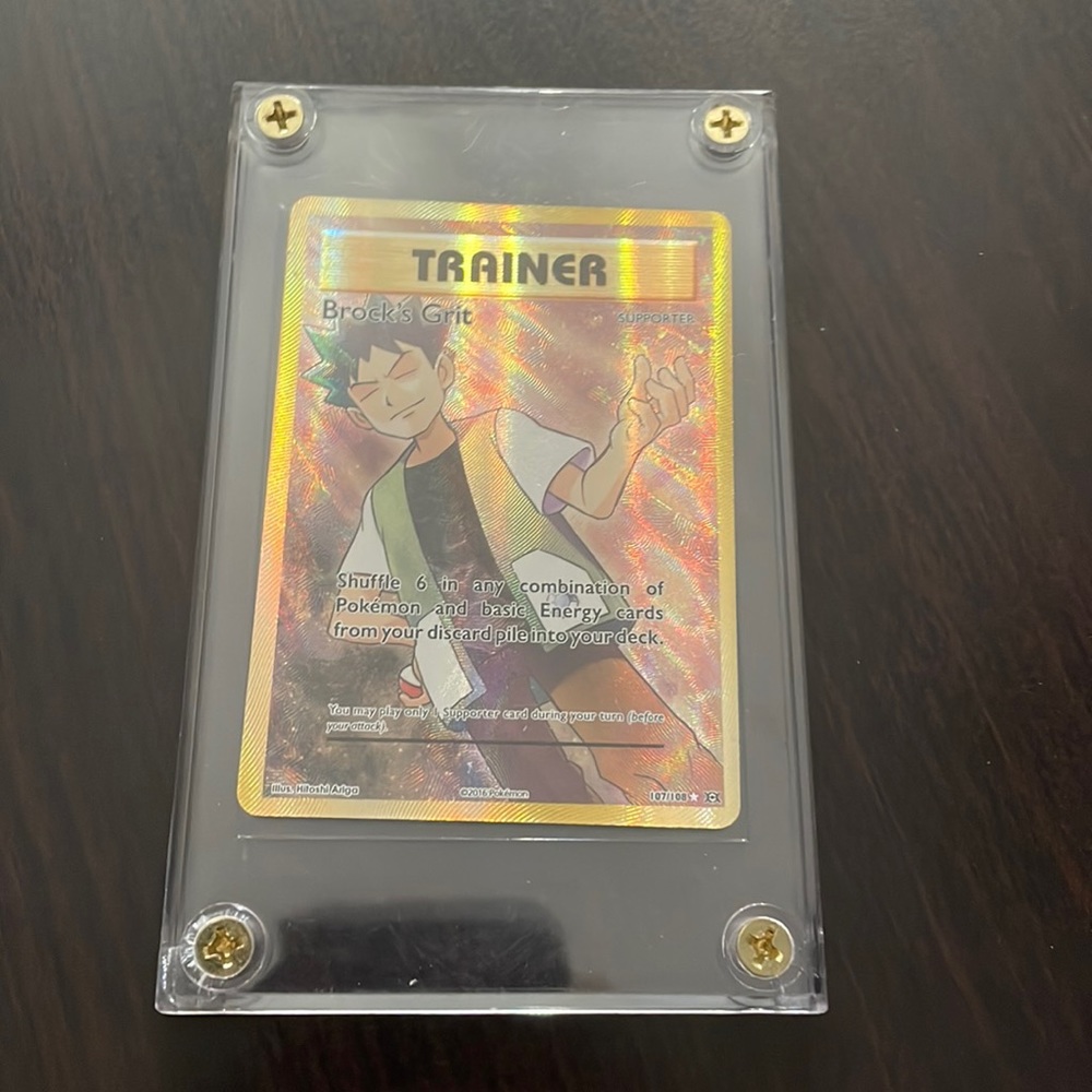Pokémon card encased Trainer BROCK’S Grit